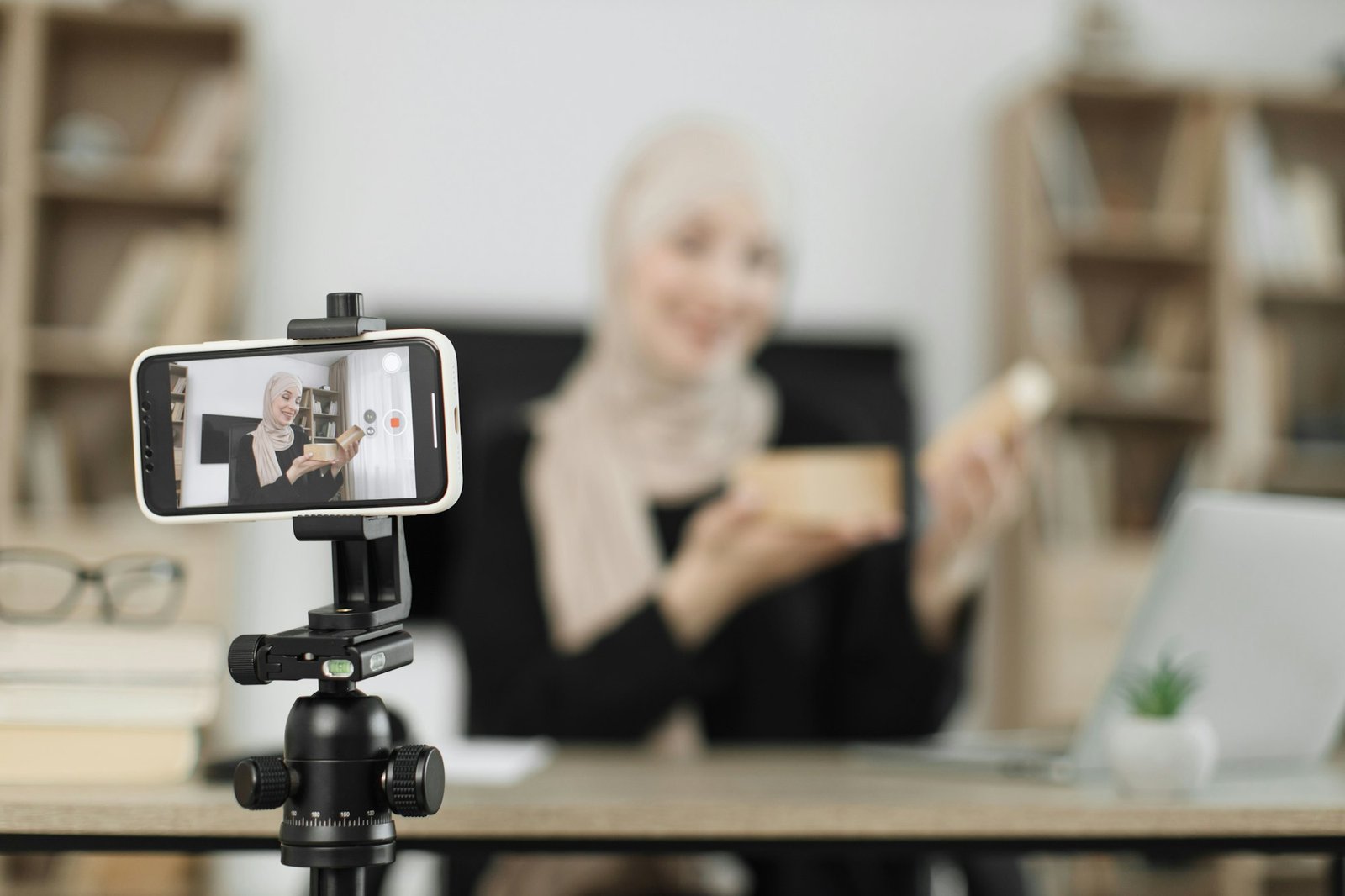 Arab woman using smart phone camera for creating content.