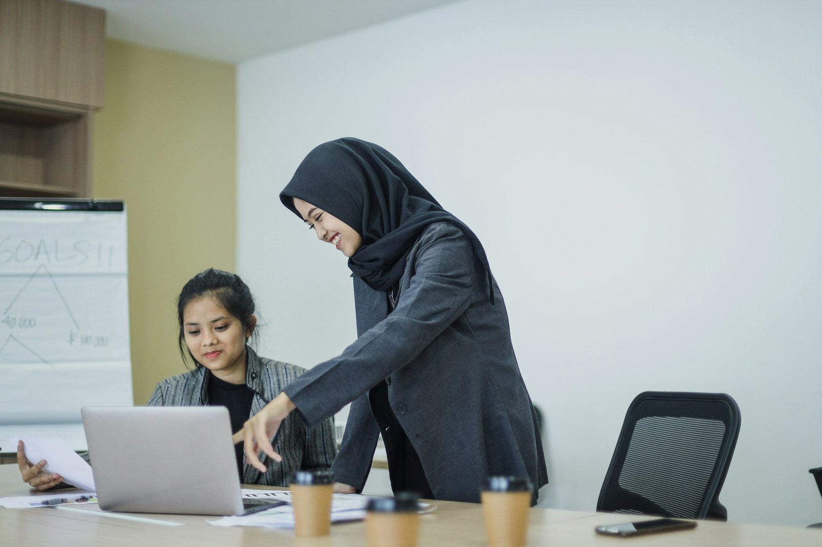 Businesswoman pointing at laptop screen,training and mentoring new employee